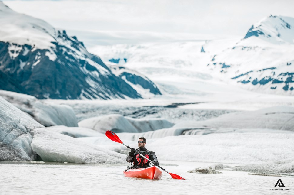 man solo kayaking glacier lagoon at heinabergslon