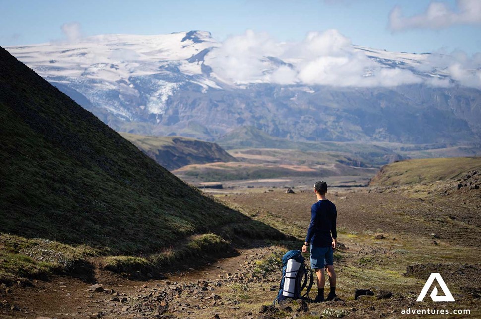 a man stopping and watching the mountains in iceland