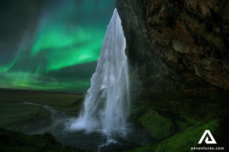 northern lights above seljalandsfoss waterfall
