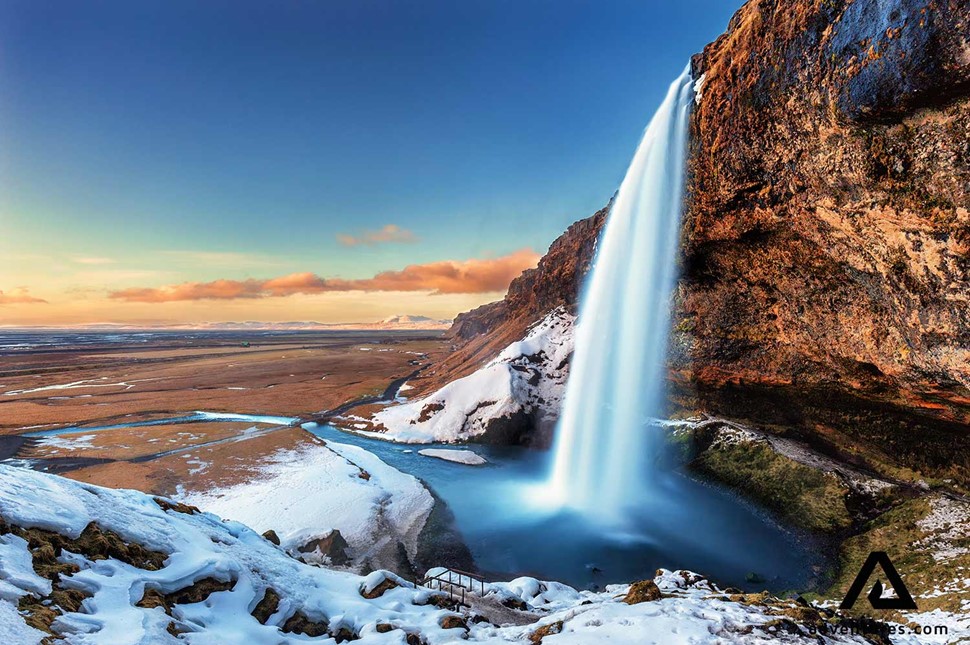 sunset near a snowy waterfall seljalandsfoss in iceland