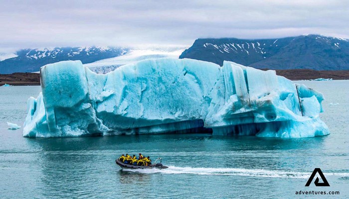 a zodiac boat near a big iceberg in Jokulsarlon