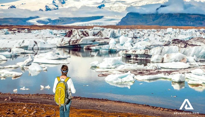 a man walking around the glacier lagoon path