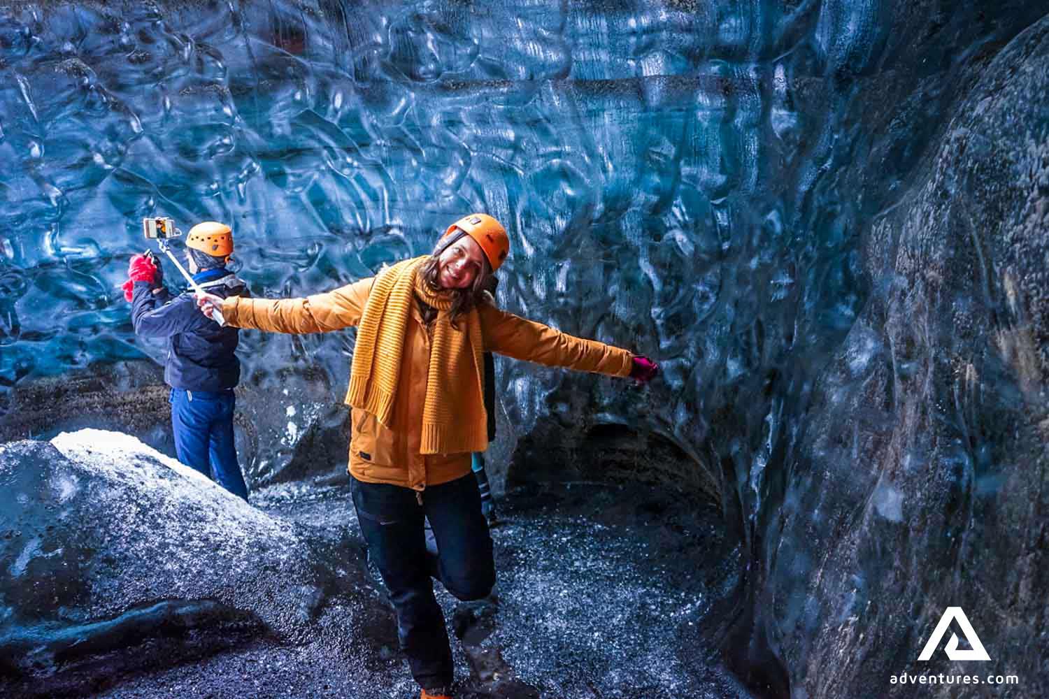 happy woman inside katla ice cave in iceland