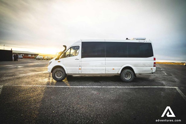 a sightseeing minibus in a parking lot in iceland