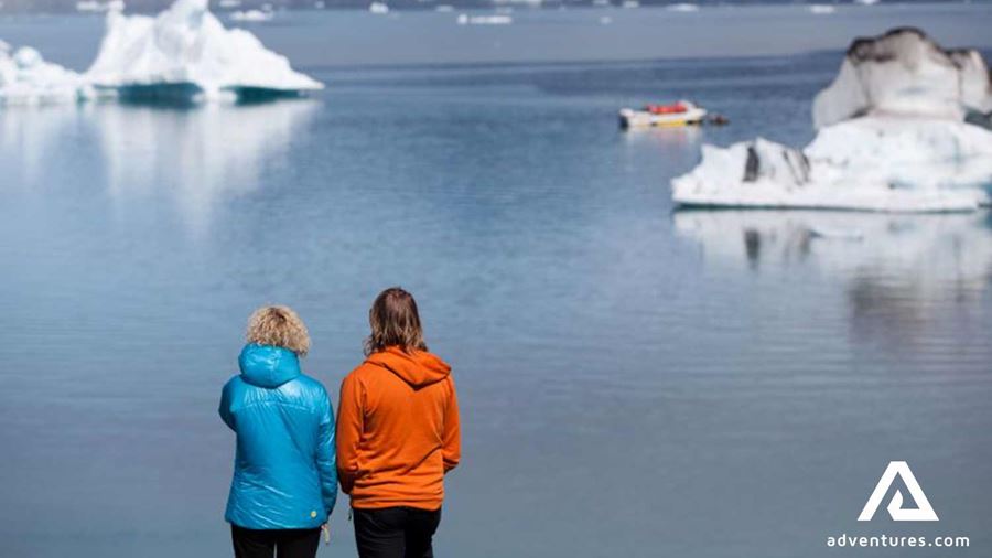 two woman watching a boat in a lagoon