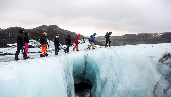 group walking on a glacier in line