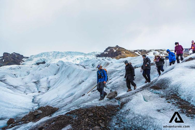 Small group of people walking down a glacier Small group of people walking down Falljokull