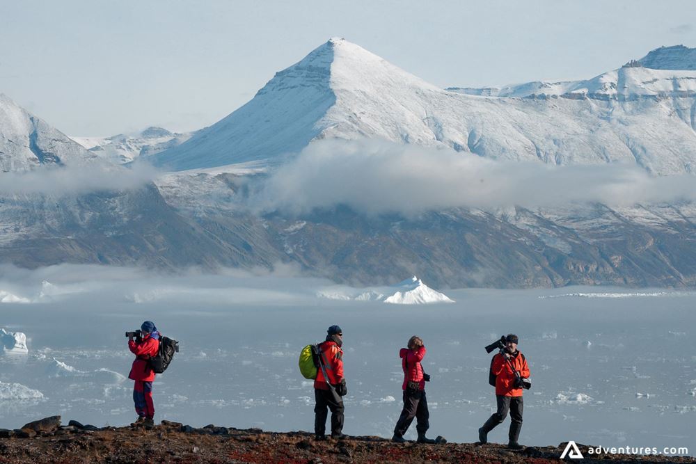 Group of tourists exploring Glacier Arctic from behind Greenland sea