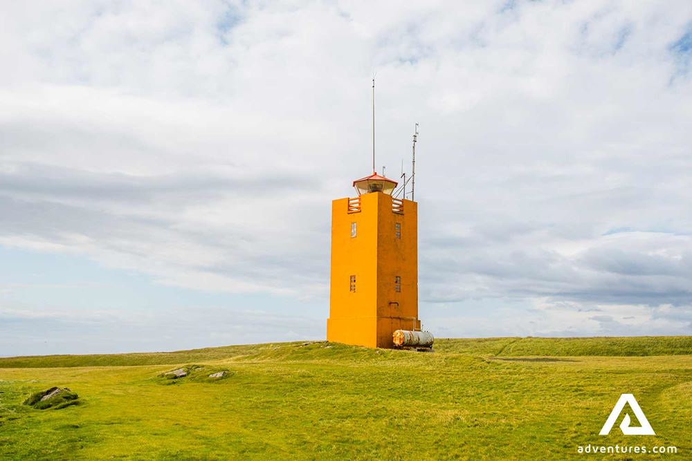 orange lighthouse in ingolfshofdi