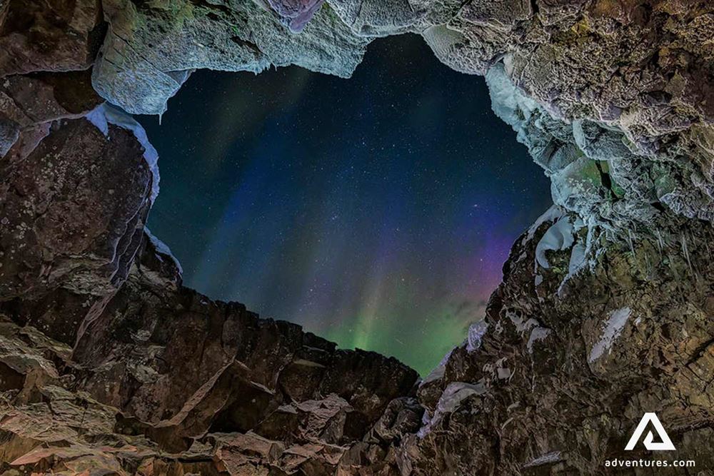 northern lights view through and opening in a cave