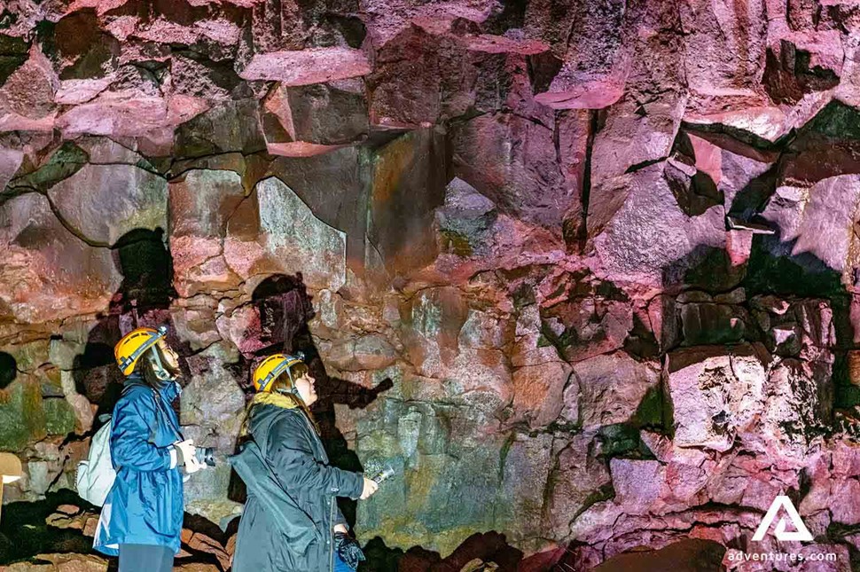 two friends exploring lava cave with flashlights