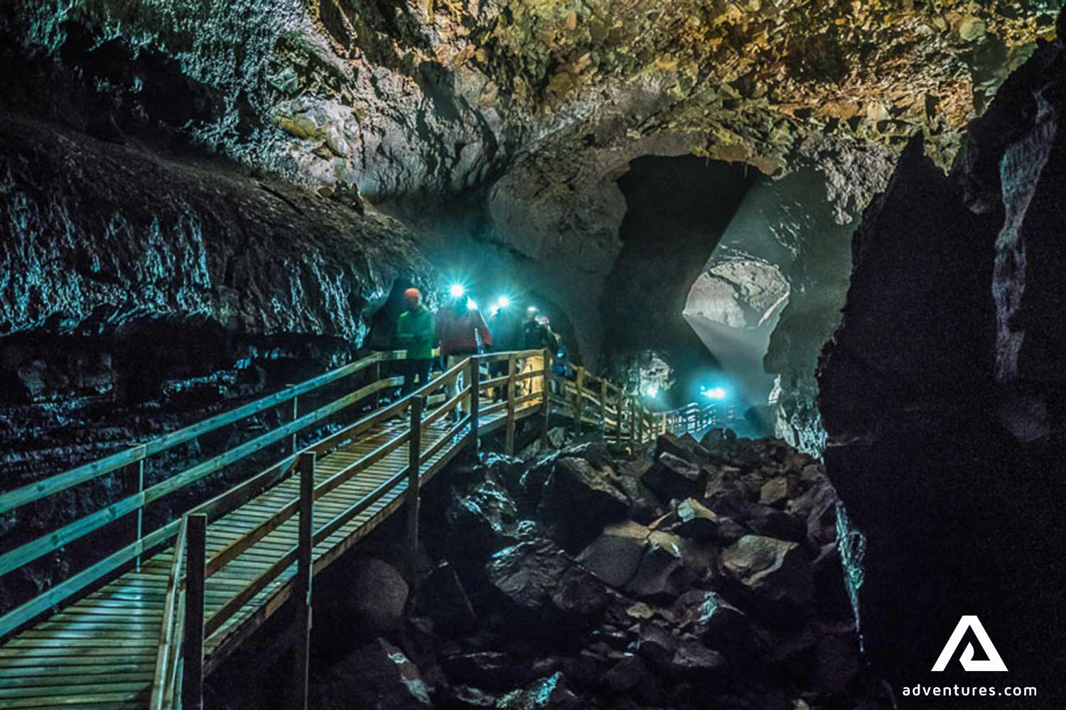 group with head flashlights exploring lava cave vidgelmir