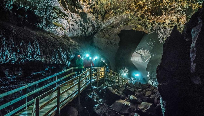 group with head flashlights exploring lava cave vidgelmir