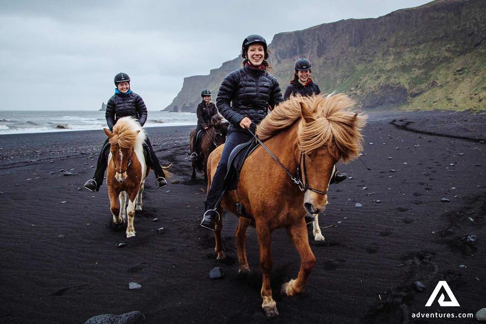 happy small group riding horses on a rainy day