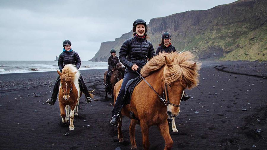 happy small group riding horses on a rainy day