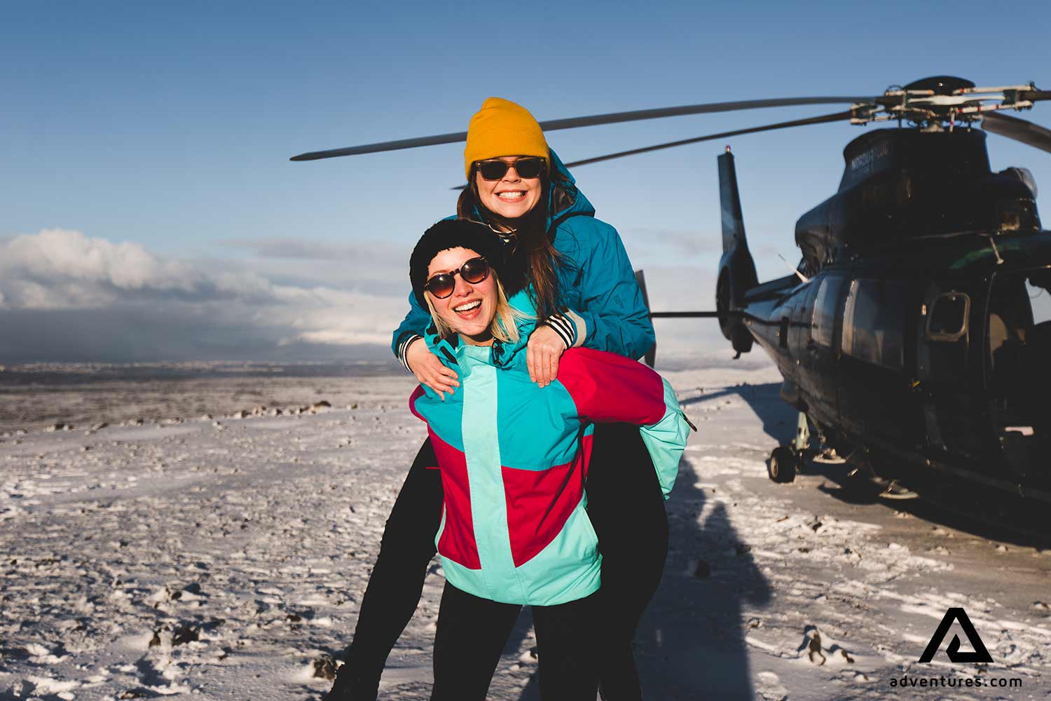two happy friends on a helicopter tour in winter