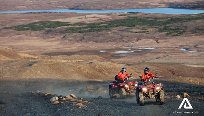 view from a mountain of people riding atvs in iceland