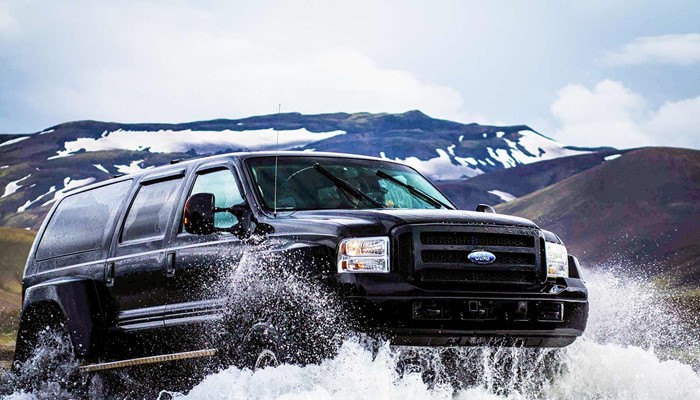 black super truck crossing glacial river in iceland