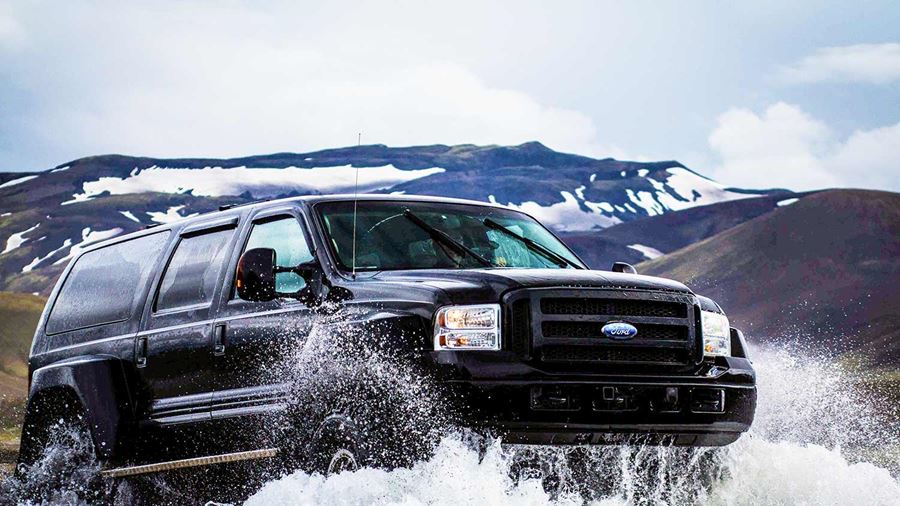black super truck crossing glacial river