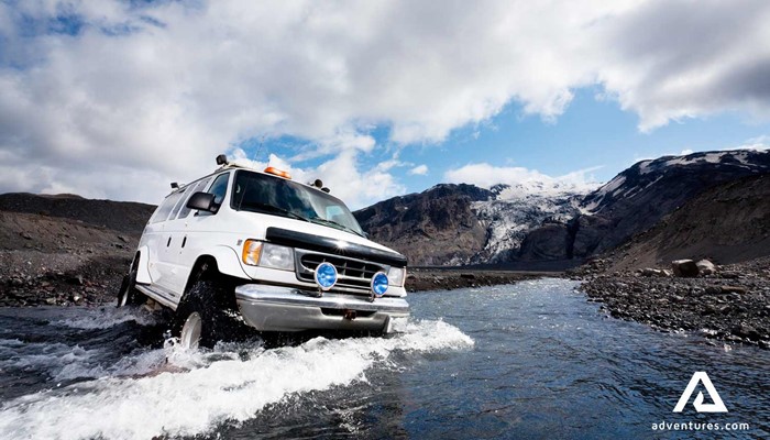 super jeep minibus crossing glacial river in iceland