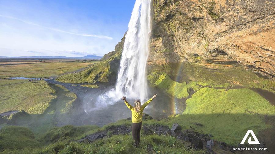 happy woman near seljalandsfoss waterfall