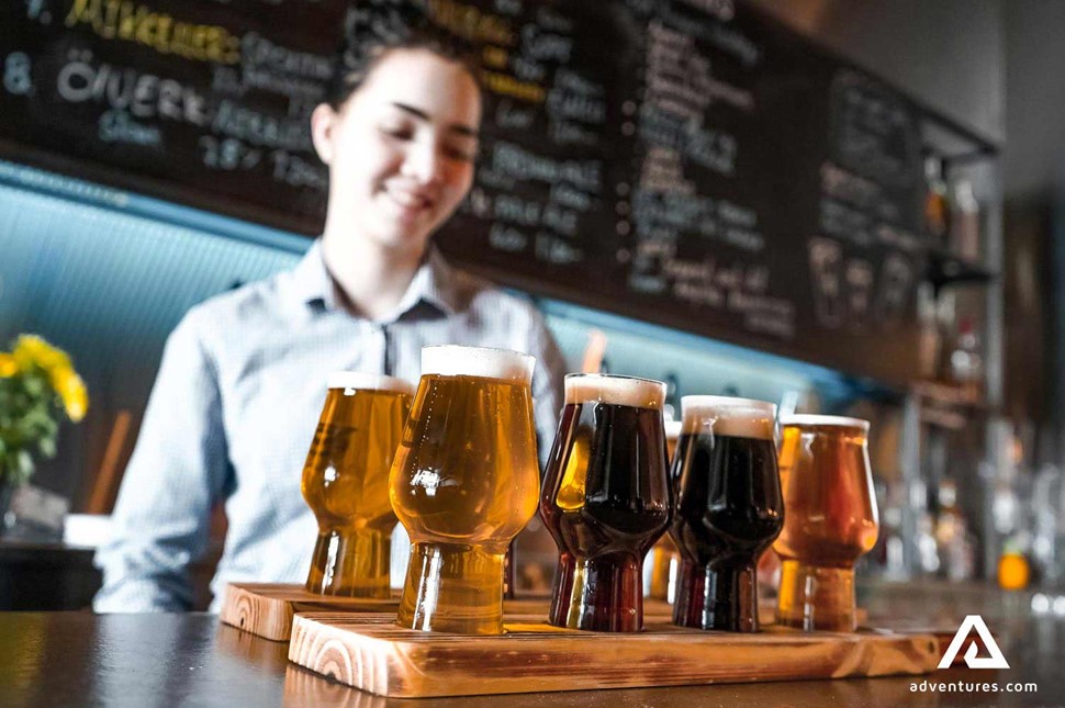 bartender with a tray of beer tasting glasses
