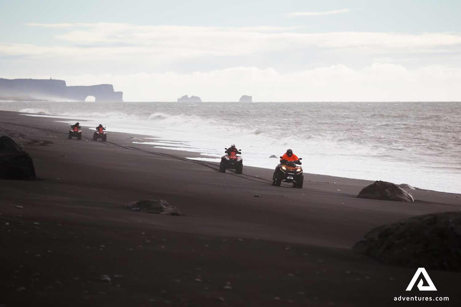 riding atvs on a black sand beach in south iceland