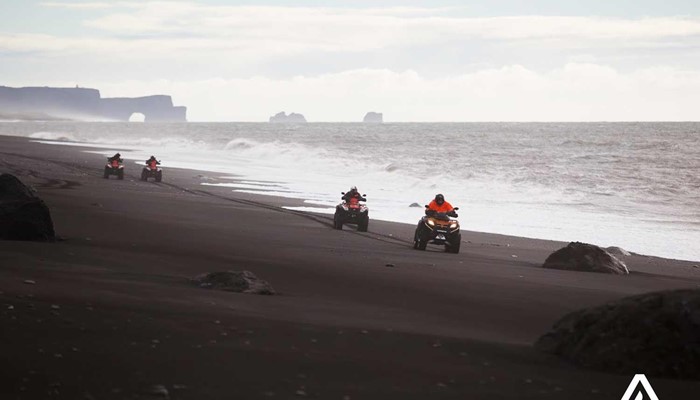 riding atvs on a black sand beach in south iceland