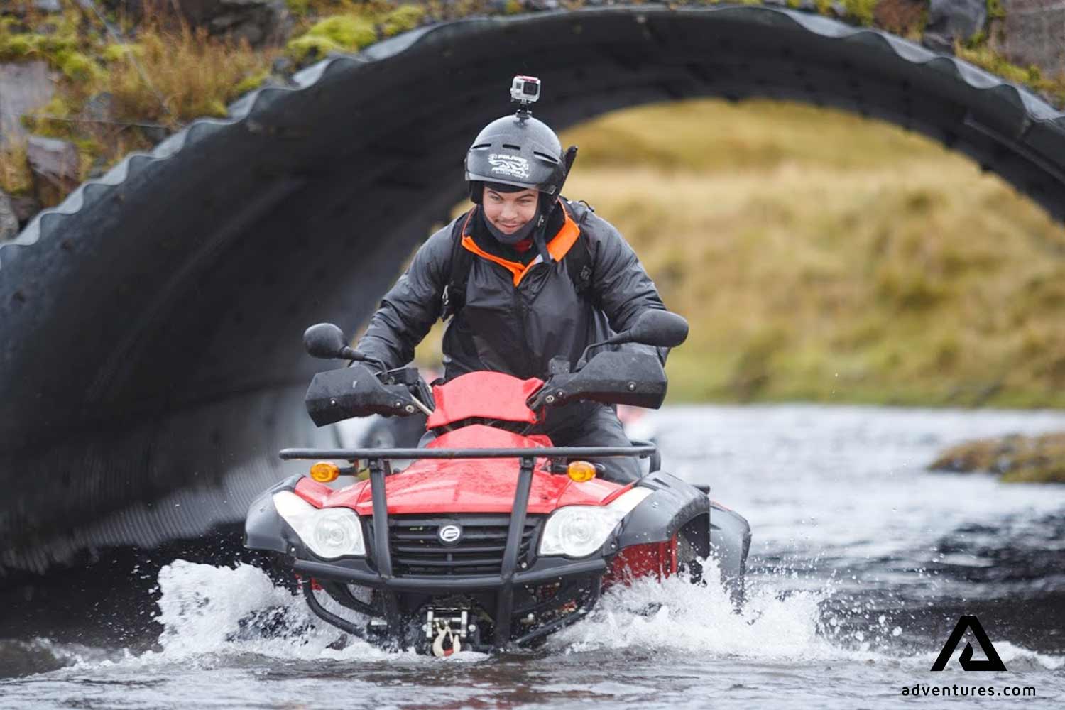 riding atvs through a deep tunnel with water in solheimasandur