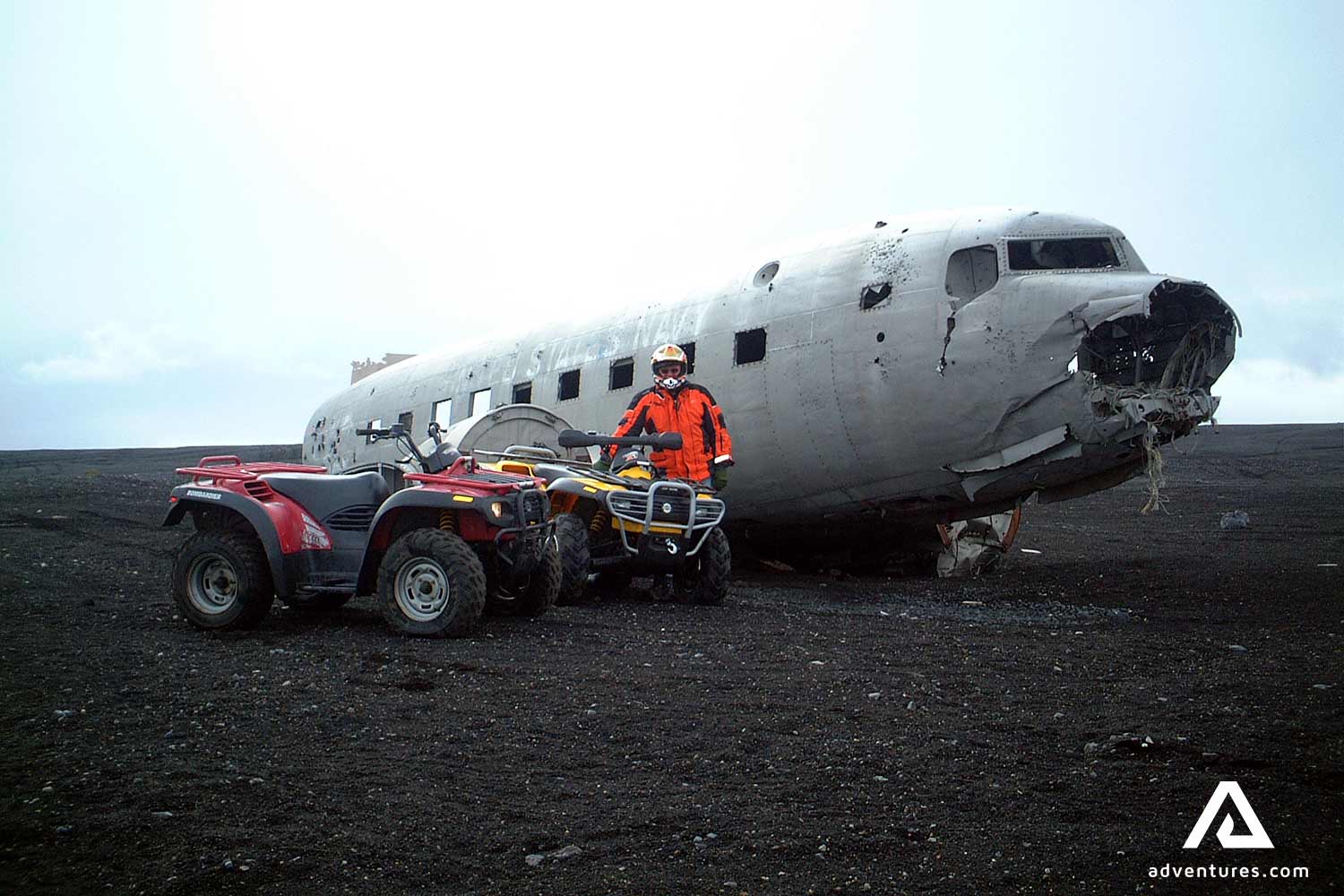 man with an atv next to a plane wreck in iceland