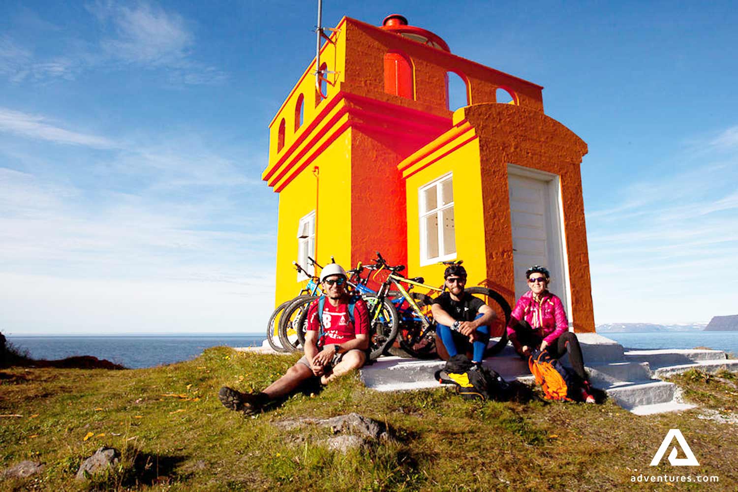people resting near a small lighthouse