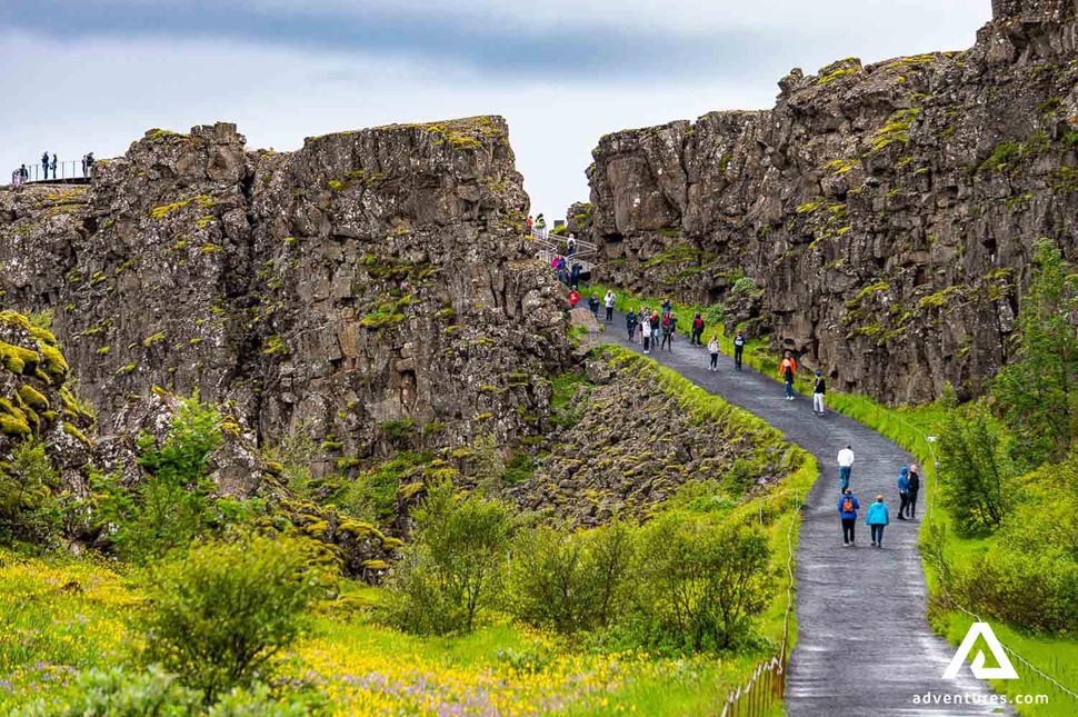 people walking down a path in Thingvellir national park in Iceland