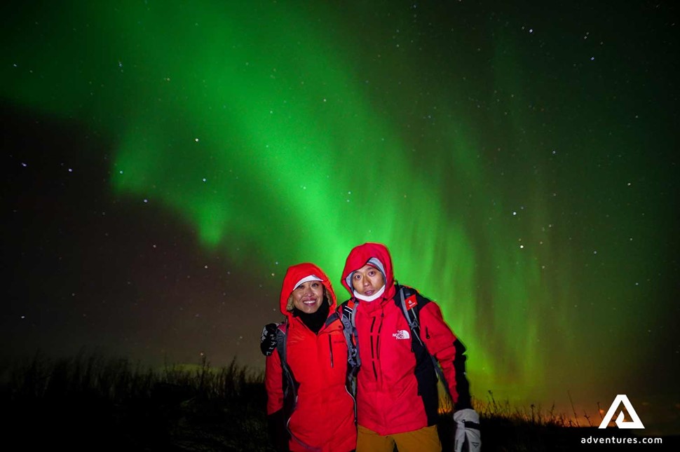 a happy couple on a northern lights watching tour in Iceland