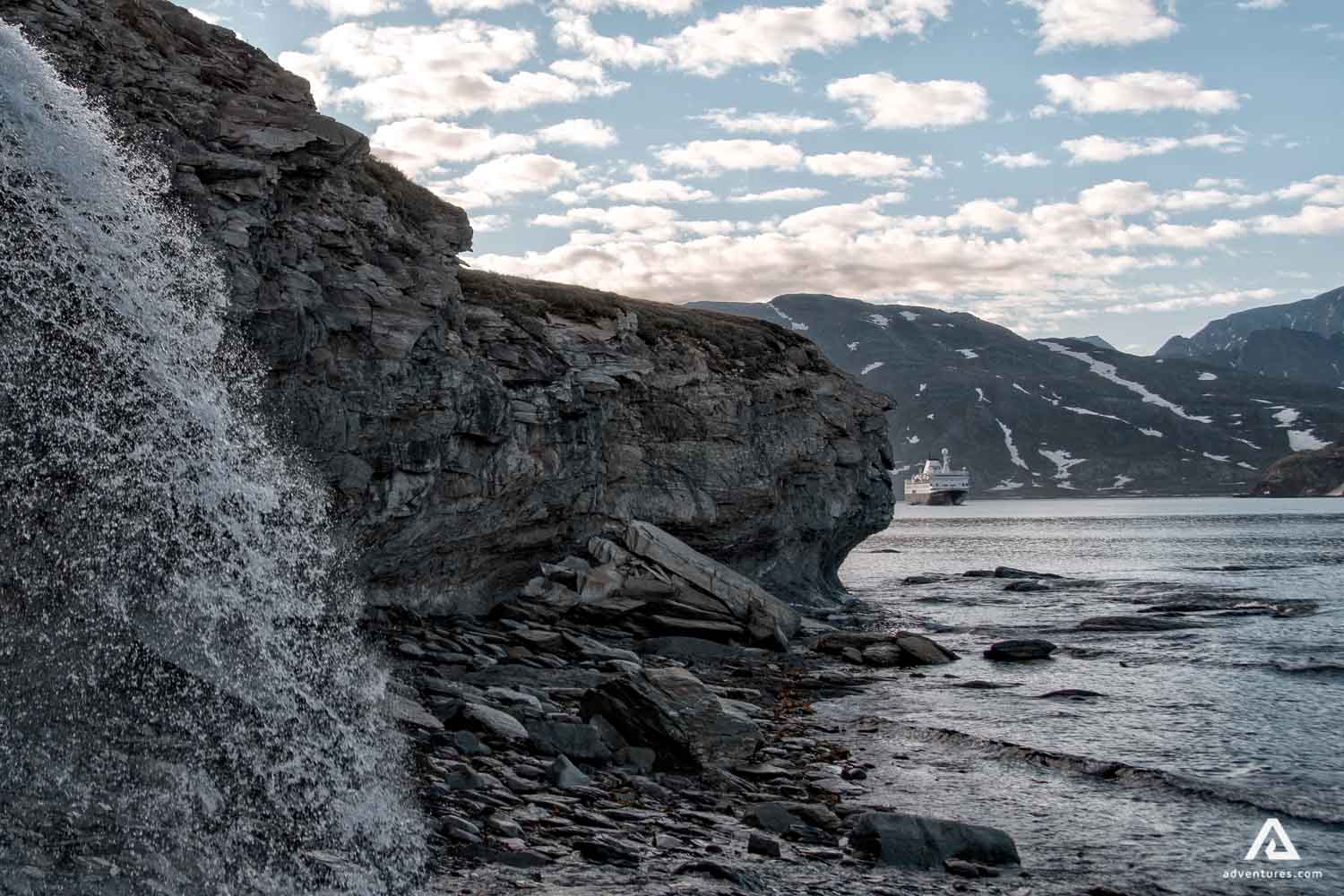 Rocky mountain waterfall at shore