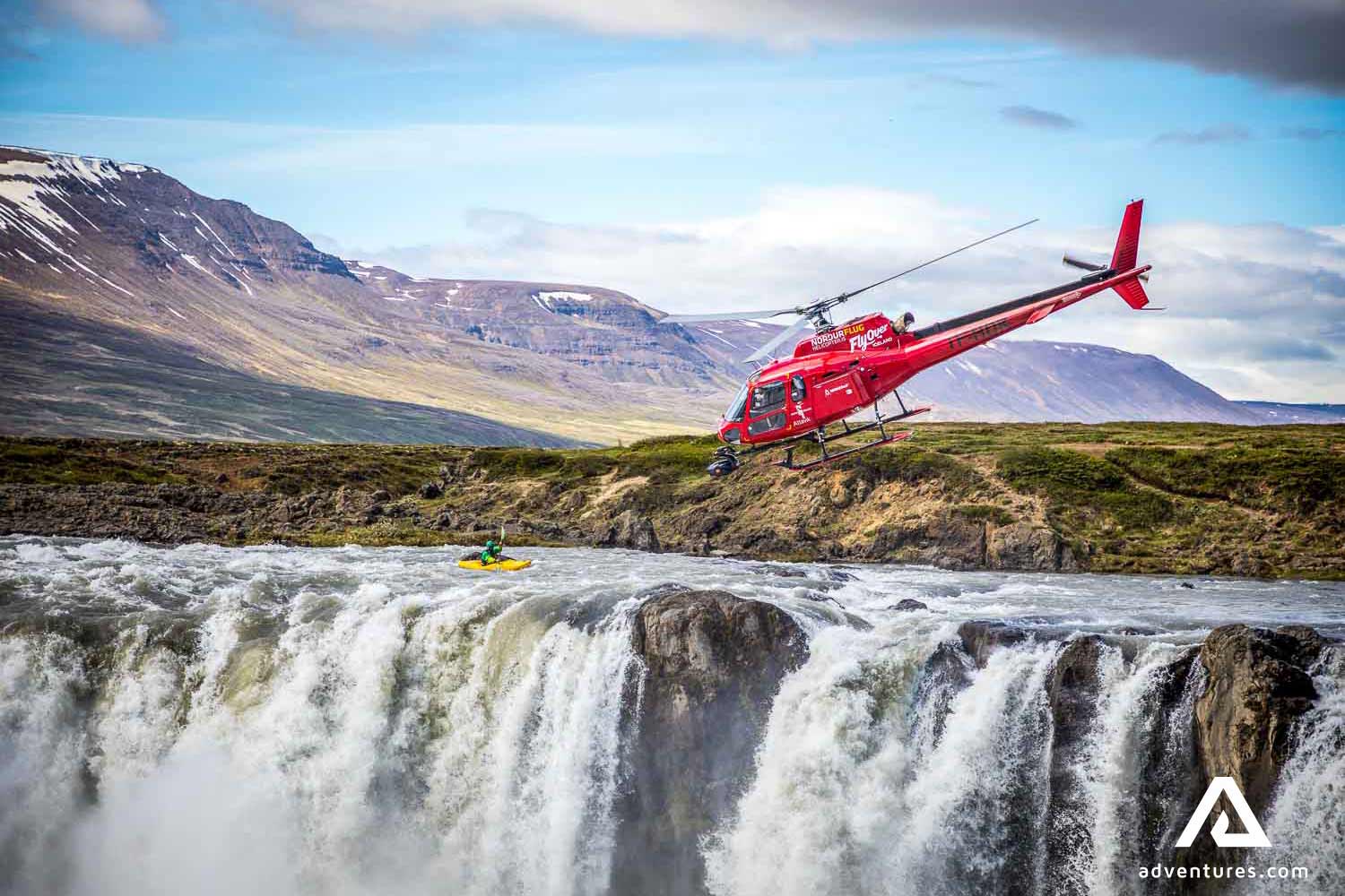 helicopter flying over a waterfall with a camera in iceland