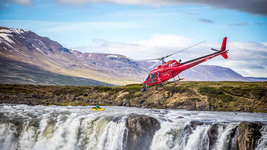 helicopter flying over a waterfall with a camera