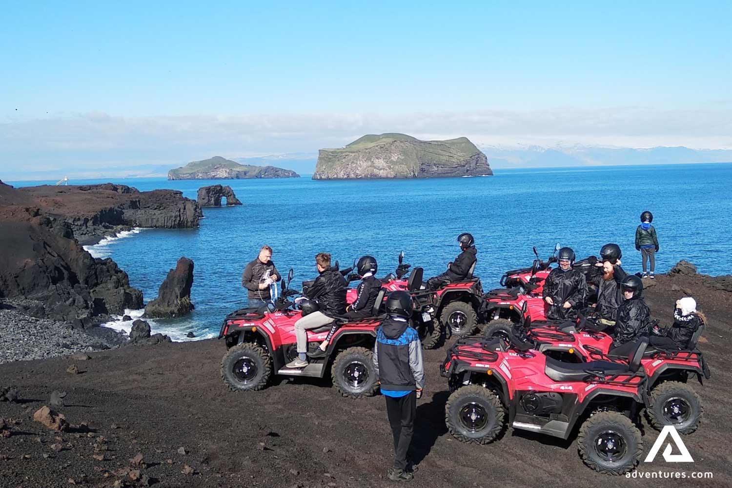 big group riding atvs in vestmannaeyjar near cliffs