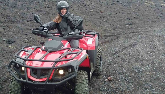 woman posing for a picture on a quad bike tour in vestmannaeyjar