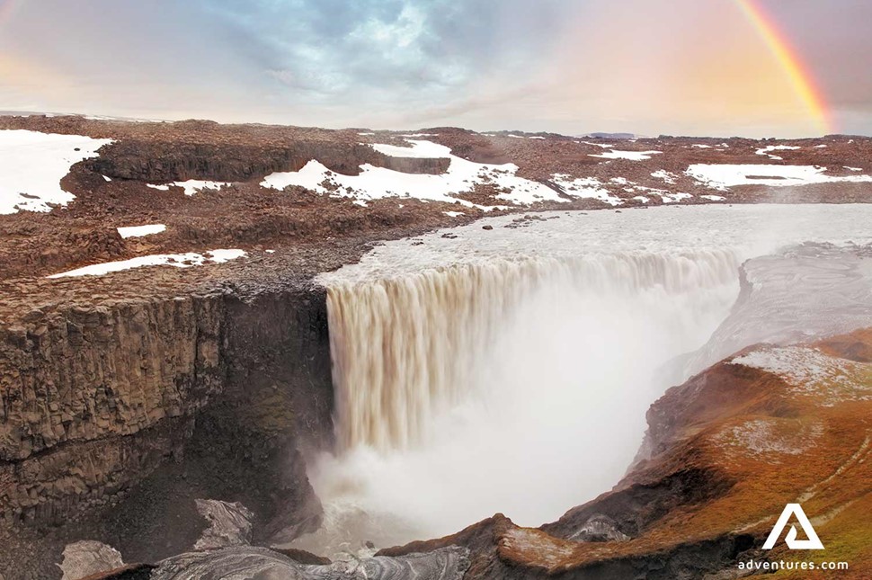 dettifoss waterfall with a rainbow on the side in winter