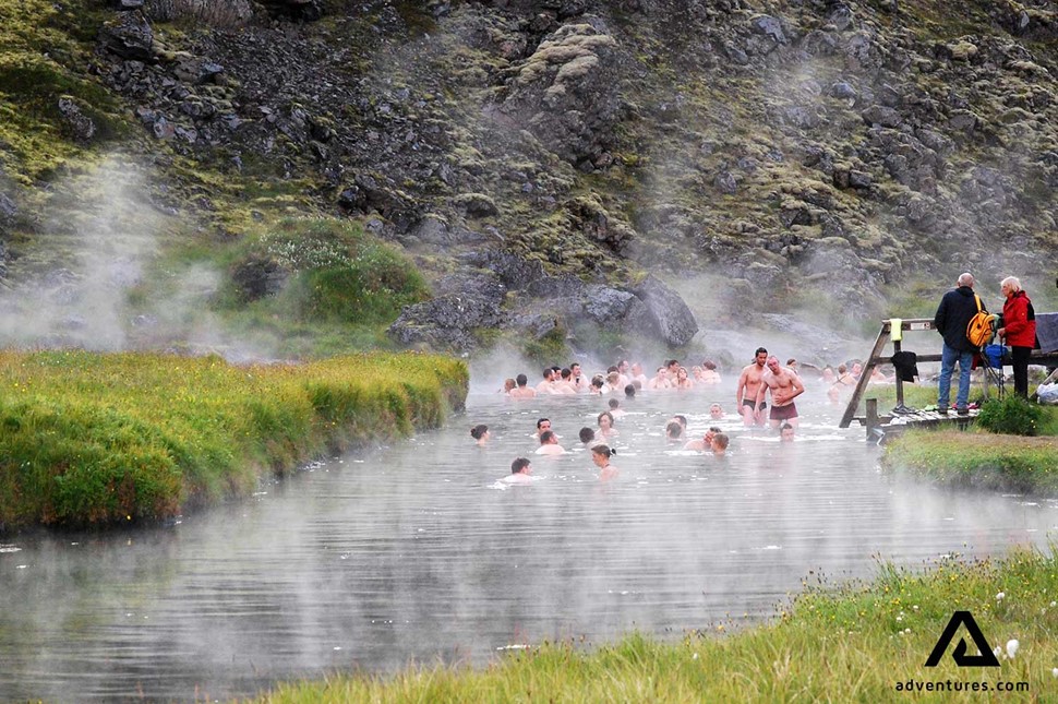 people bathing in a hot spring in landmannalaugar