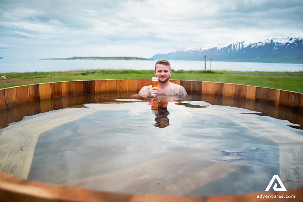 man with beer in a hot tub outside the beer spa