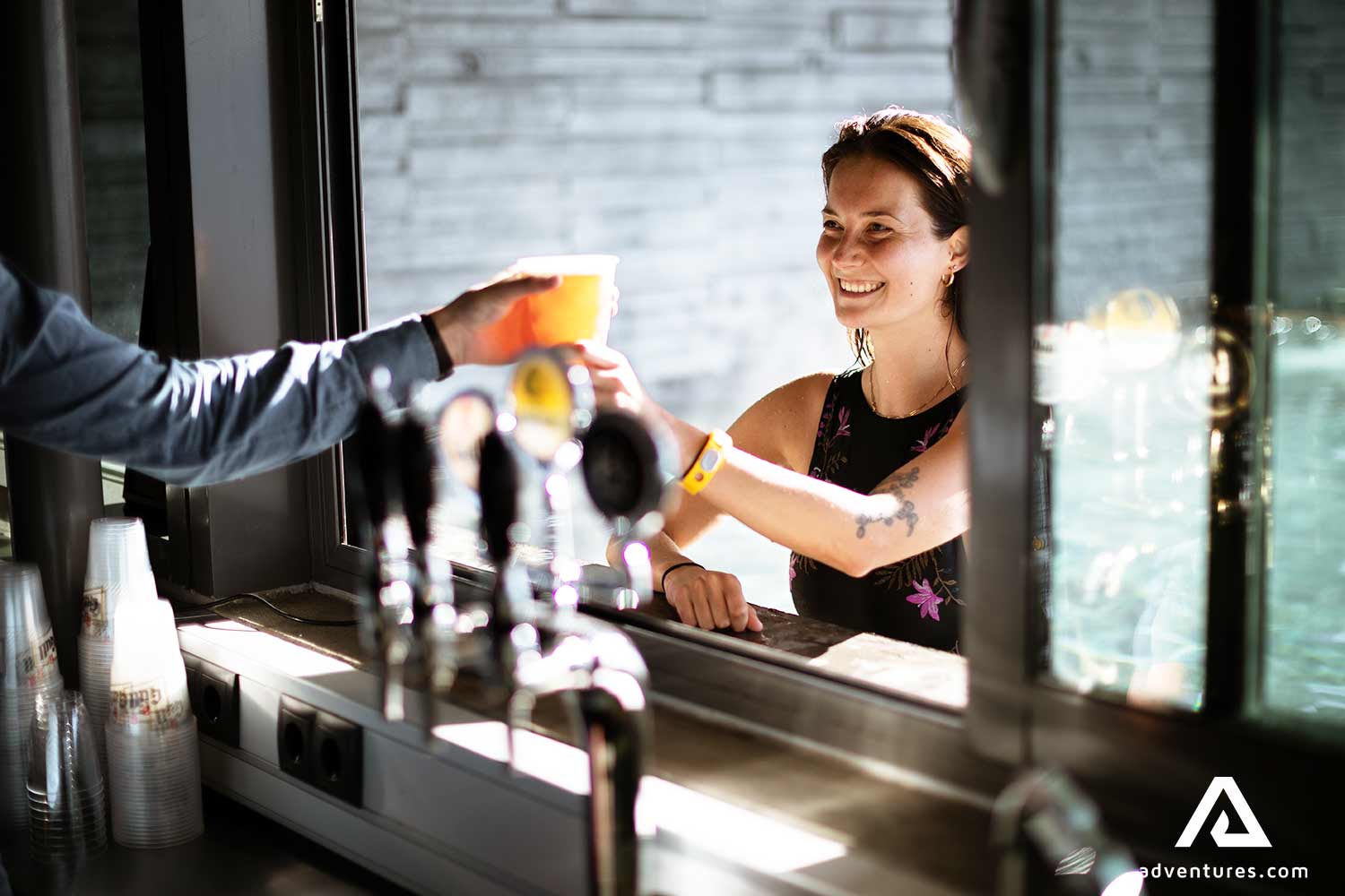 woman taking a cocktail from a bar