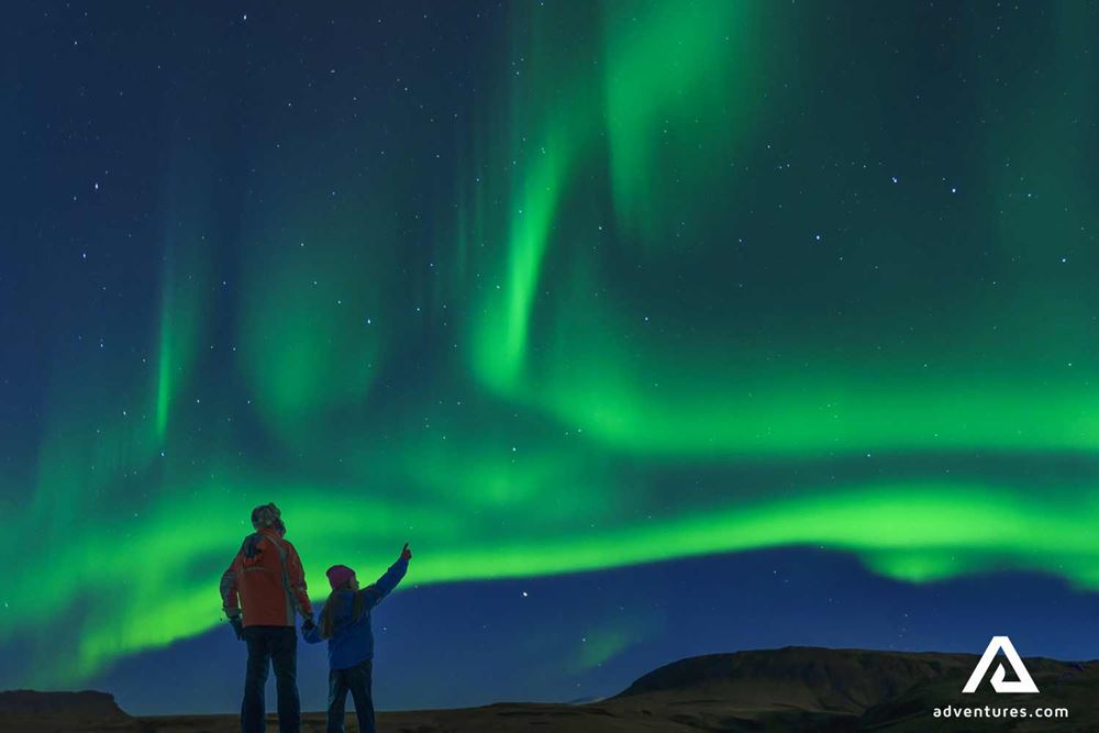 father and son watching aurora borealis