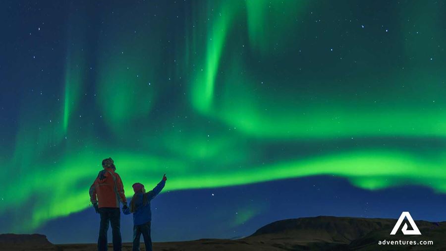 father and son watching aurora borealis
