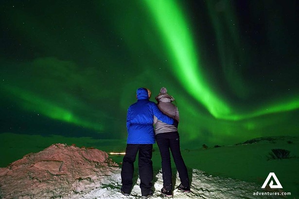 couple watching aurora borealis in iceland
