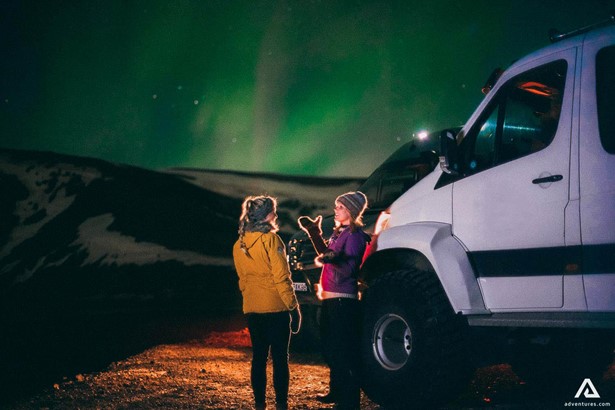 northern lights near super jeeps in iceland