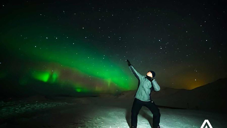 man posing for a picture near northern lights
