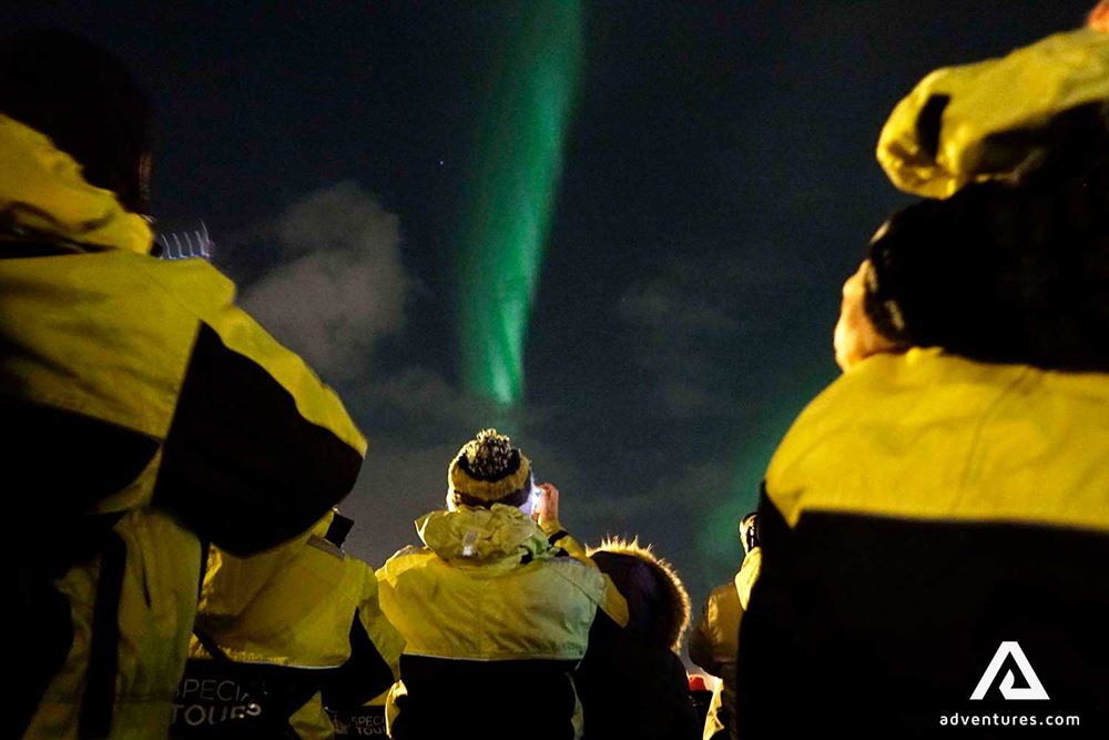 group of people taking pictures of northern lights