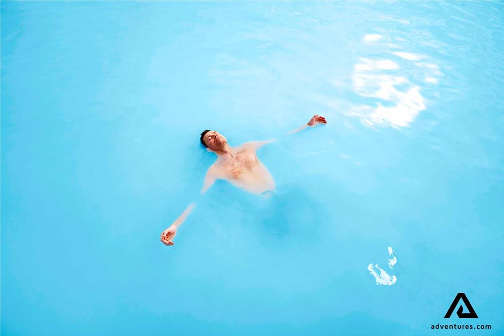 a man bathing in the blue lagoon in reykjanes
