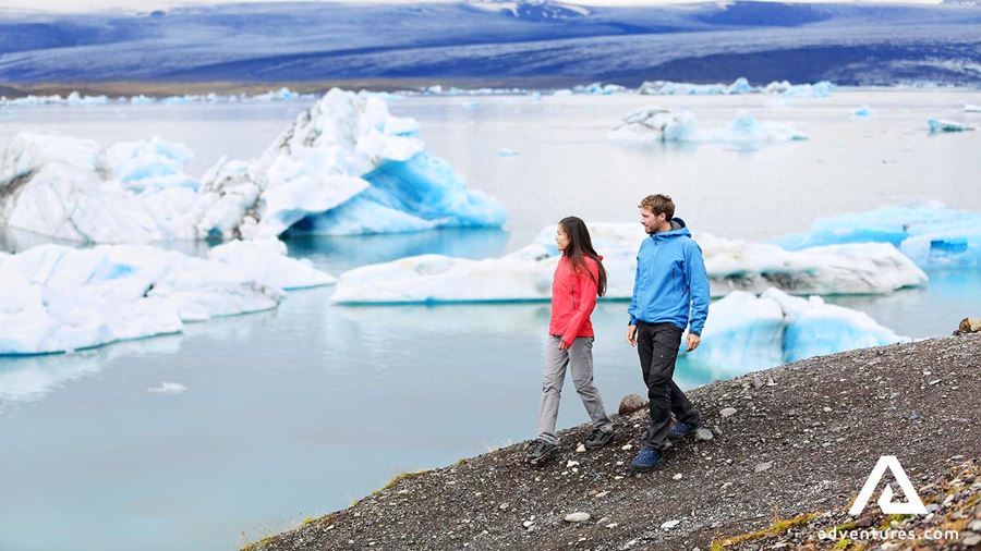 couple walking around jokulsarlon glacier lagoon 